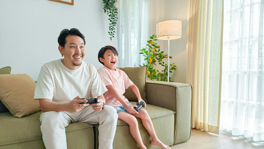 Father and son playing video game holding controlers